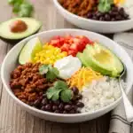 Easy taco rice bowl with seasoned beef, beans, and fresh toppings.