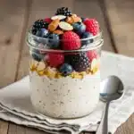 Guilt free overnight oats in a jar with berries and honey drizzle.