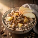 High fiber apple cinnamon oatmeal in a rustic ceramic breakfast bowl.