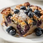 Golden brown blueberry baked oatmeal slice with honey and fresh berries.