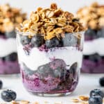 Layered blueberry yogurt parfait with Greek yogurt and crunchy granola in a jar.