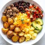Breakfast burrito bowl with eggs sausage potatoes beans rice and avocado