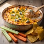 Creamy buffalo chicken dip with melted cheese and fresh vegetable dippers.