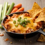 Creamy red hot buffalo chicken dip with celery and chips for dipping.