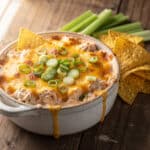 Creamy cheesy crock pot buffalo chicken dip with celery and chips.