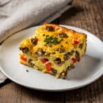Golden brown cheesy egg bake breakfast casserole with sausage and peppers.