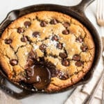 Golden brown chocolate chip skillet cookie with melted chips and vanilla ice cream.