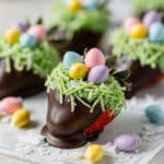 Easter chocolate covered strawberries with coconut nest hold candy eggs.