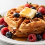 Classic golden brown waffles with maple syrup, butter, and fresh berries.