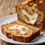 Moist banana bread slice with creamy swirls of cream cheese filling.