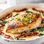 Creamy Tuscan chicken with sun-dried tomatoes and spinach in a skillet