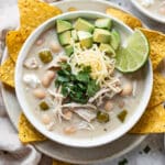 Creamy slow cooker white chicken chili with avocado and cheese topping