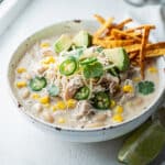 Creamy white chicken chili with cream cheese in a rustic ceramic bowl
