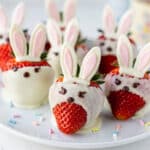 Easter chocolate covered strawberries with bunny ear toppers on rustic board