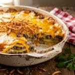 Golden hobo casserole with ground beef and melted cheese in a baking dish.