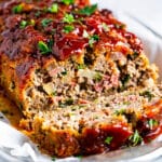 Classic homestyle meatloaf slice with a glossy ketchup glaze on a white plate.