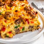 Sausage egg hash brown casserole slice with crispy cheese and bell peppers.