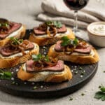 Steak crostini with horseradish sauce and caramelized onions on toasted baguette.