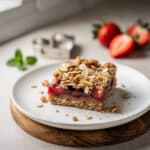 Strawberry oatmeal crumble bar with jammy filling and oat topping.