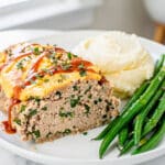 Moist turkey meatloaf slice with herbs and glossy mustard ketchup glaze.