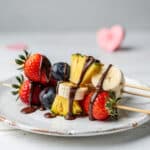 Fresh fruit skewers with chocolate drizzle for Valentine's Day dessert.