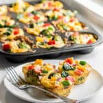 Golden brown veggie egg muffins with melted cheese and colorful spinach bell peppers
