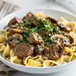 Creamy crockpot beef stroganoff with mushrooms served over egg noodles