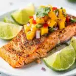 Cajun salmon with mango salsa on rustic board in close up food photo