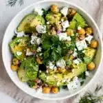Creamy chickpea feta avocado salad with lemon herb dressing in rustic bowl