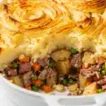 Corned beef hash shepherds pie with golden cheesy mashed potato topping in skillet