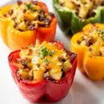 Savory corned beef hash stuffed peppers with potatoes onions and melted cheese