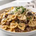 Creamy parmesan garlic beef bowtie pasta plated in a bright homemade style