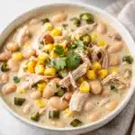 Creamy white chicken chili recipe in a rustic bowl with fresh toppings.