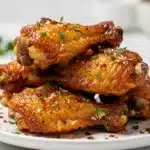 Crispy parmesan garlic wings with ranch on a rustic wooden board.