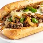 Ground beef Philly cheesesteaks on toasted hoagie rolls with melted provolone cheese.