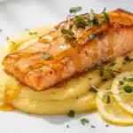 Honey mustard glazed salmon with lemon and dill on white plate