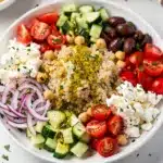 Colorful Mediterranean quinoa power bowl with fresh vegetables and feta cheese.
