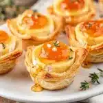Mini Brie Bites with puff pastry, apricot preserve, honey, and thyme.