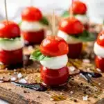 Mini Caprese bites with mozzarella, tomato, and basil on skewers.