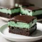 Mint chocolate brownies with creamy mint layer and glossy chocolate glaze.