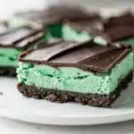 Fresh mint chocolate cookie bars with layered cream filling on a marble slab.