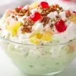 Creamy pistachio dessert salad with pineapple marshmallows and cherries in trifle bowl