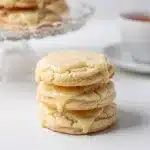 Close up of soft sugar cookies with vanilla glaze on a rustic board