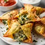 Crispy golden spinach artichoke wontons with creamy filling and marinara dip