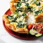 Spinach and feta egg bake slice with a golden crispy top on white plate