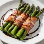 Asparagus prosciutto bundles drizzled with balsamic glaze and Parmesan cheese.