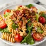 Creamy BLT pasta salad with bacon, tomatoes, and lettuce in a bowl.