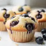 Moist homemade blueberry cupcakes topped with creamy glossy vanilla buttercream frosting.