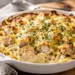Golden bubbly chicken alfredo bake with creamy pasta and parsley garnish.