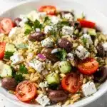 Cold Mediterranean orzo salad with feta olives and fresh herbs plated